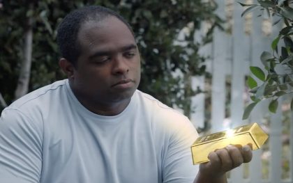 Man holding glowing gold bar