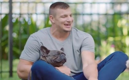 Man smiling with French bulldog outdoors
