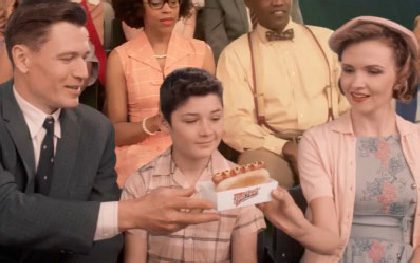 Family sharing a hot dog at event