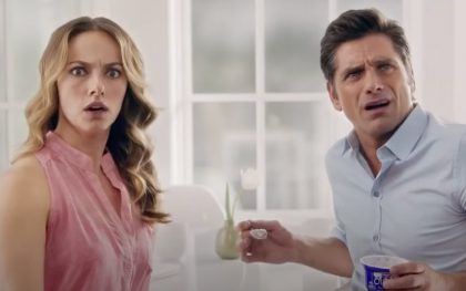 Surprised couple holding yogurt cup