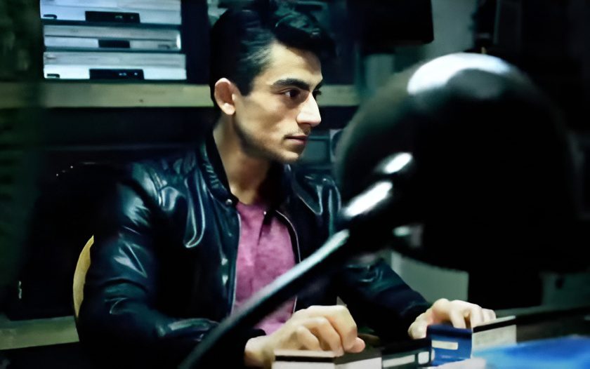 Man in leather jacket sitting at desk
