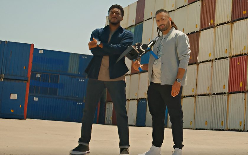 Two men standing by shipping containers